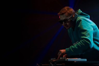Bir gece kulübünde DJ iş. Club disko ışığı. DJ pikap arkasında.
