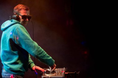 Bir gece kulübünde DJ iş. Club disko ışığı. DJ pikap arkasında.