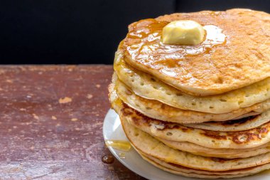 Karanlık bir tablo üzerinde akçaağaç soslu krep.
