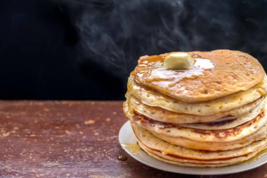 Karanlık bir tablo üzerinde akçaağaç soslu krep.