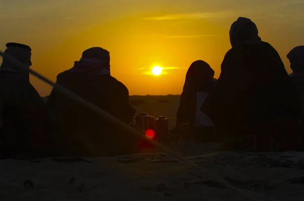 Des hommes autour d'une cheminée dans le désert au lever du soleil — Photo
