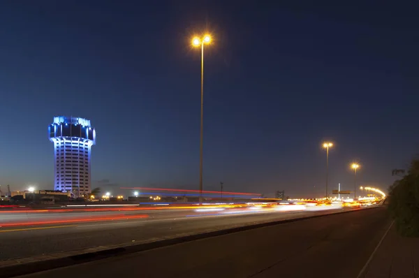 Château d'eau de Jeddah la nuit, avec des feux de voiture mouvement sur la stree — Photo