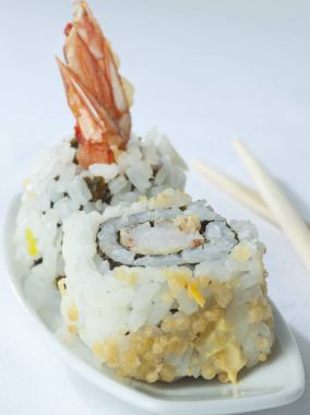 Yakın çekim yemek çubukları ile suşi plaka, iki adet