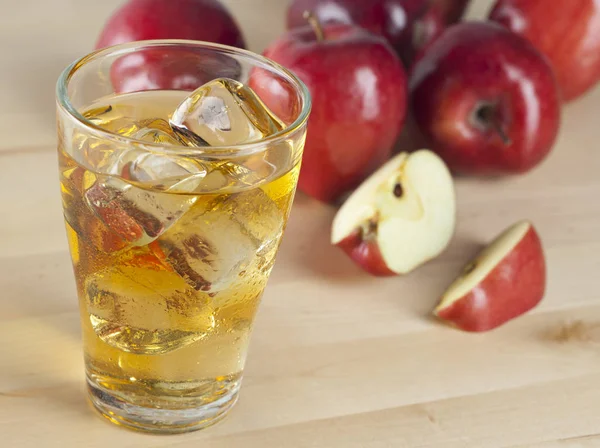 Sklenici čerstvé studené jablečný džus s ledem vedle jablka — Stock fotografie