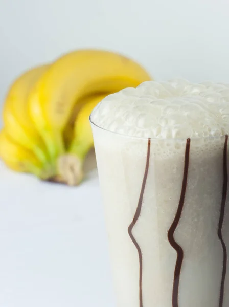 Um copo de banana e coquetel de leite de perto com frutas cheias — Fotografia de Stock
