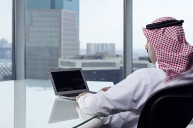 Laptop çalışma düşünürken izleyen Suudi Arap adamım