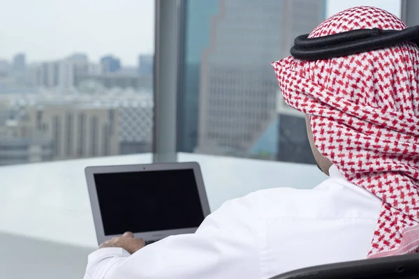 Саудівська арабських чоловік спостерігає ноутбук на роботу споглядаючи — стокове фото