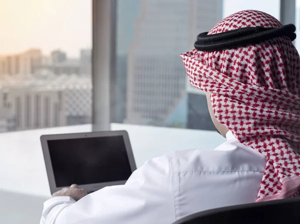 Hombre árabe saudí mirando el ordenador portátil en el trabajo contemplando — Foto de Stock