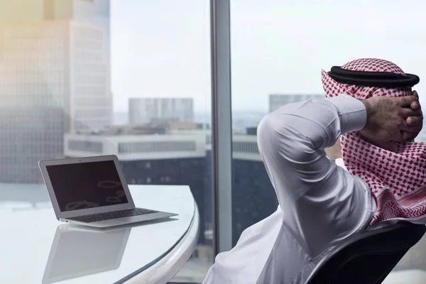 Саудівська арабських чоловік спостерігає ноутбук на роботу споглядаючи — стокове фото