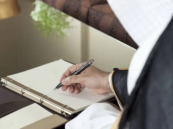 Saudi Arabian Man Hand Writing on A Notebook