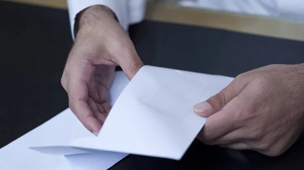 Businessman hands opening an envelope