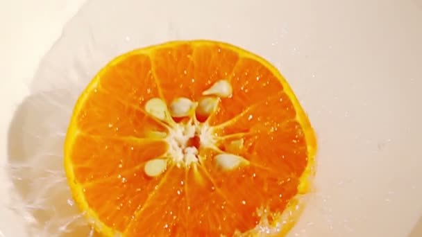 ゆっくりとした動きでオレンジの果実に水が飛び散る — ストック動画