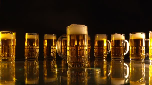 宙に浮く泡と黒い背景に金色の色調を持つグループビールグラス — ストック動画