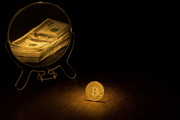 Bitcoin altın sikke 100 dolar faturaları, siyah bir arka plan iş kavramı bir paket şeklinde bir aynada yansıyan.
