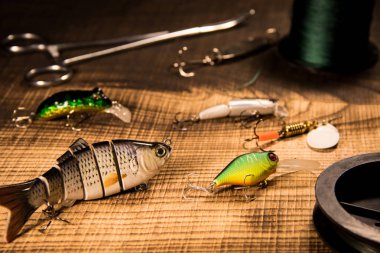 Dişli balıkçılık, ahşap arka plan, üstten görünüm sallananlarla ve çeşitli yem yırtıcı bir hayvan üzerinde yapay yem kordonlar ve kavram Balık tutma bir ahşap arka plan üzerinde maşa