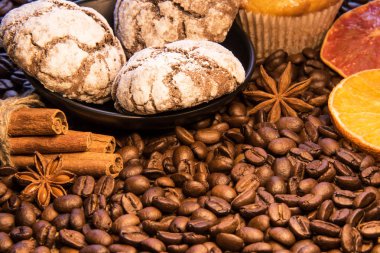 Kahve dağınık fasulyeli çikolata kurabiye tarçınlı kek, yeşil dal ve sliceed orang sopa yanında bir tabak var