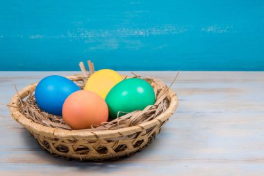 Boyalı Paskalya yumurtaları yazıt için bir yer ile mavi bir arka plan üzerinde sepet