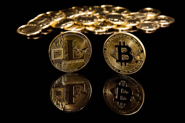 Criptocurrency bitcoin y litecion monedas en la superficie del espejo negro junto a las monedas de oro — Foto de Stock