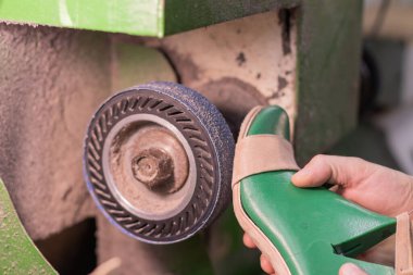 Ayakkabıcı, kadın ayakkabılarını zümrüt makinesinde, ayakkabı yapma konseptinde işliyor.