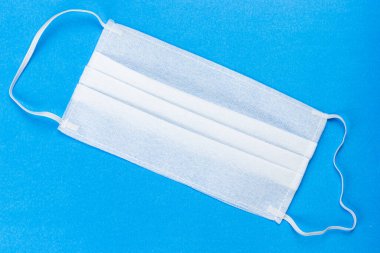 Kulaklıklı yüz maskesi 3 katlı, mavi arka planda güvenlik maskesi. toz koruma solunum cihazı ve solunum maskesi.