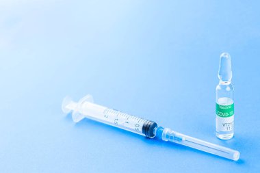 Corona virüsü Covid-19 - şırıngalı aşı konsepti - kopyalanmış mavi arka planda tepeden tırnağa desen