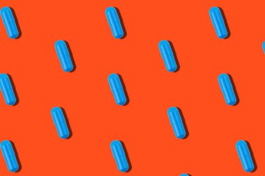 Turuncu arka planda mavi haplarla kusursuz desen. Tıp sağlığı eczacılık konsepti.