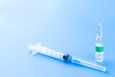 Corona virüsü Covid-19 - şırıngalı aşı konsepti - kopyalanmış mavi arka planda tepeden tırnağa desen