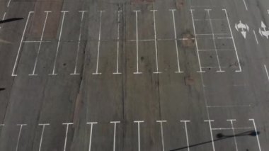 Coronavirus covid-19 karantinası sırasında alışveriş merkezinin yakınındaki boş araba parkında yürüyen yalnız bir kadın..