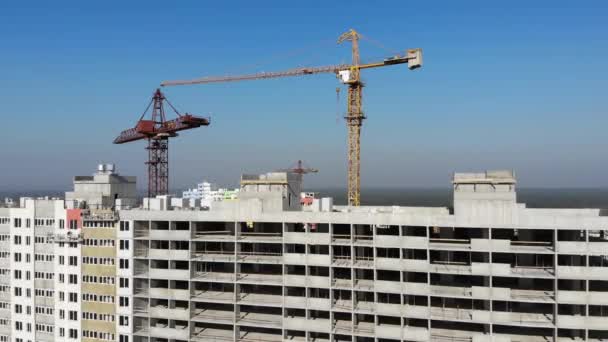 Grúa de construcción en el sitio de construcción vertical volando hacia abajo a la vista aérea superior — Vídeos de Stock
