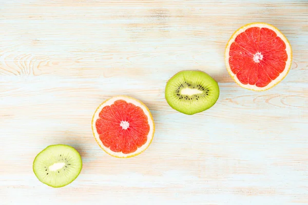 Minimal Frukt Bakgrund Ovanifrån Skivade Citrusfrukter Grapefrukt Och Kiwi Blått — Stockfoto