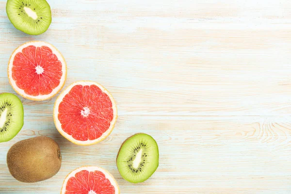 Minimaler Fruchthintergrund Draufsicht Auf Geschnittene Zitrusfrüchte Grapefruit Und Kiwi Auf lizenzfreie Stockfotos