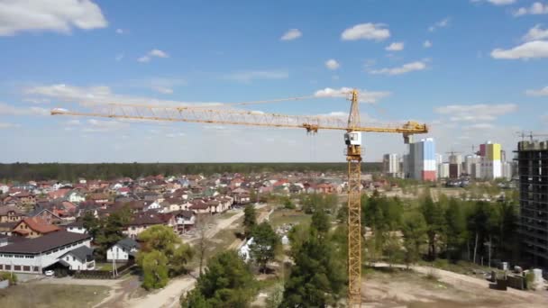 Hög byggarbetsplats. Stor industriell torn kran med blå himmel amd stadsbild på bakgrunden. — Stockvideo