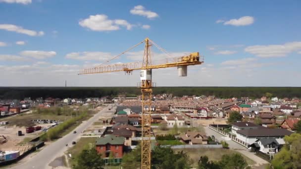 Высокая строительная площадка. Большой промышленный кран с голубым небом на фоне городского пейзажа . — стоковое видео