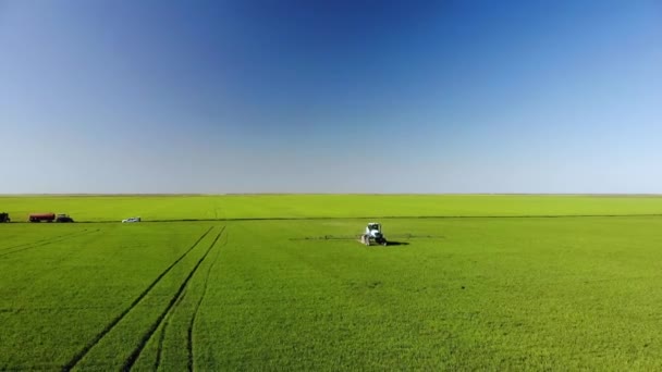 Vue aérienne du labour et de la pulvérisation de tracteurs agricoles sur le terrain — Video