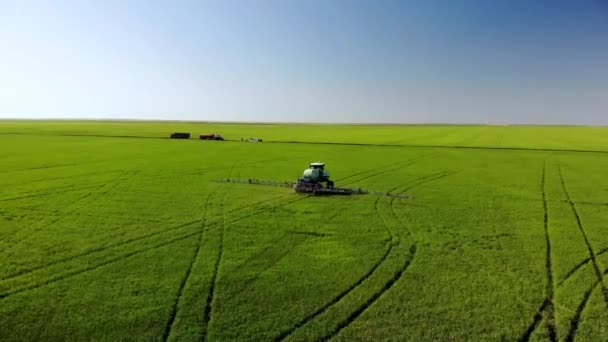 Landbouwmachines die insecticide spuiten op het groene veld, agrarische natuurlijke seizoensgebonden lentewerken. — Stockvideo