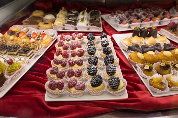 さまざまなおいしいケーキがバイヤーの関与についての店のショー ウィンドウに表示されます — ストック写真