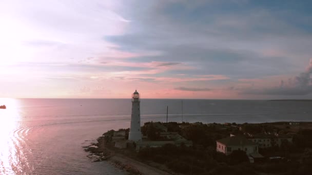 Drone schot vuurtoren strand vuurtoren zonsondergang. Vuurtoren op een achtergrond van prachtige zonsondergang. — Stockvideo