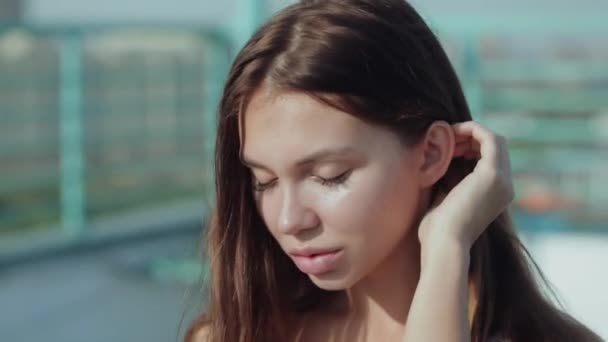 La cara pecosa de una mujer de cabello oscuro con hermosos ojos parpadea extremadamente lentamente. Atractiva joven hembra con pestañas mirando a la cámara . — Vídeos de Stock