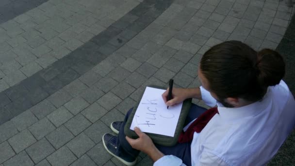 Fatigué homme écrit baise outre des signes à l'extérieur . — Video