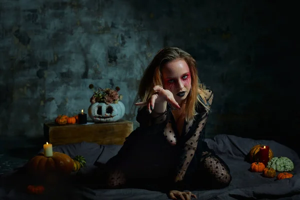 Zbliżenie portret pięknej seksownej czarownicy z makijażem halloween. czerwone i czarne malowanie twarzy. — Zdjęcie stockowe