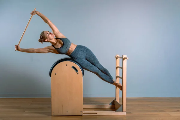 Bella donna che fa esercizio pilates, formazione su barili. Concetto di fitness, attrezzi fitness speciali, stile di vita sano, plastica. Copia spazio, banner sportivo per la pubblicità. — Foto Stock