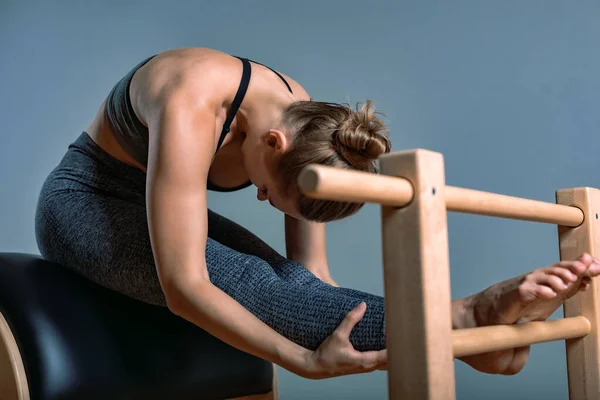 Belle femme blonde positive est en cours de préparation effectuer des exercices de pilates, formation sur l'équipement de canon. Concept de fitness, équipement de fitness spécial, mode de vie sain, plastique. Espace de copie, sport — Photo