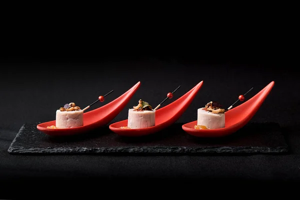 Гусиный паштет, фуа-гра, подается на черном камне в японских красных ложках. Паста с джемом и орехами. Концепция термоядерной пищи, сдержанный ключ, пространство для копирования . — стоковое фото