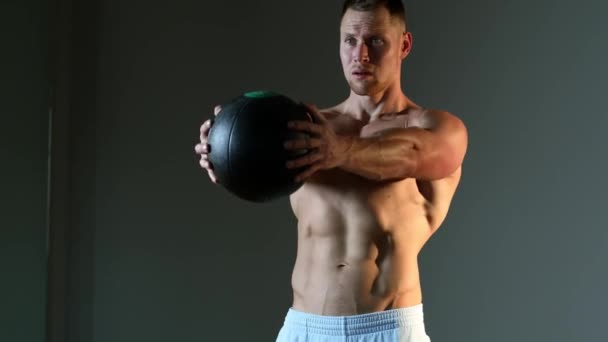 Человек делает перекресток с медицинским мячом в студии — стоковое видео