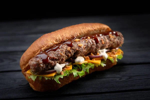 close up of kebab sandwich on black wooden background