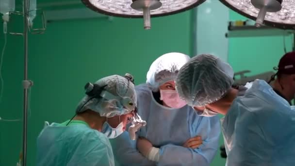 Chirurg a chirurgický tým provádějí kosmetickou operaci prsou na operačním sále nemocnice. Zvětšení prsou. Práce profesora medicíny. Prsní implantáty. — Stock video