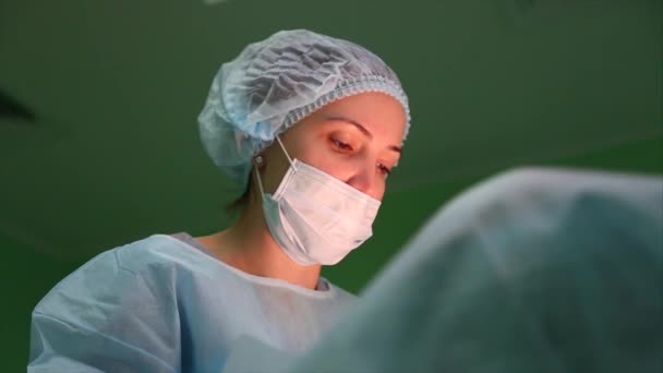 Portrait of Focused and Concentrated Surgeon Performing Surgical Operation in Modern Operating Room. The surgeon sutures a cut on the skin. — Stock Video