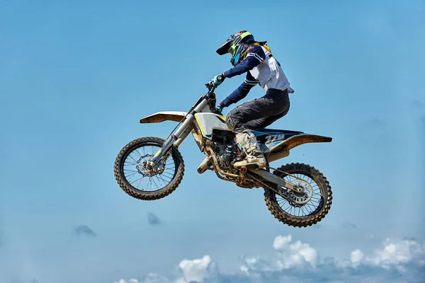 Deportes extremos, salto en moto. Motociclista hace un salto extremo contra el cielo. Efecto de grano de película, iluminación —  Fotos de Stock