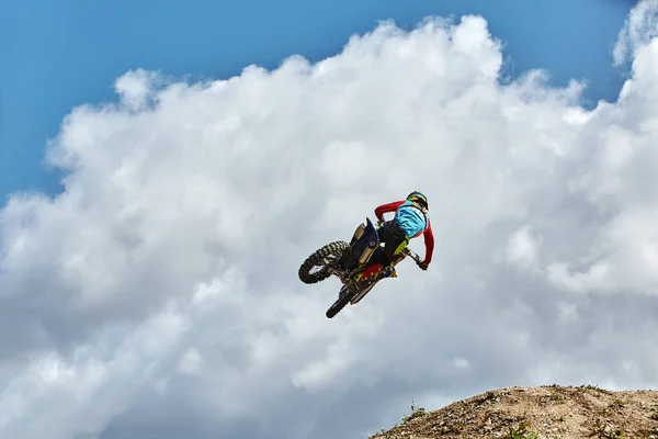 Deportes extremos, salto en moto. Motociclista hace un salto extremo contra el cielo. Efecto de grano de película, iluminación — Foto de Stock