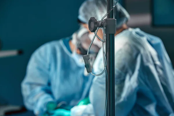 Two surgeons in protective uniform during the operation, on background of surgical room. Point of view shot — Stock Photo, Image